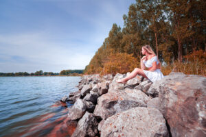 Photographie paysage automnal au bord d'un lac avec un jeune fille sur les rochers